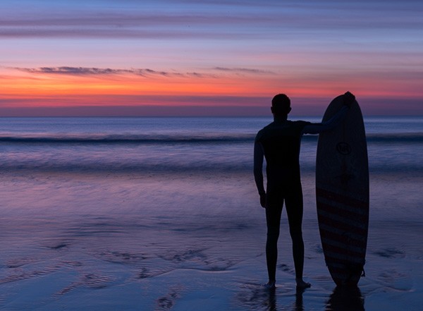 Surfer at sunrise on Fistral Beach in Newquay